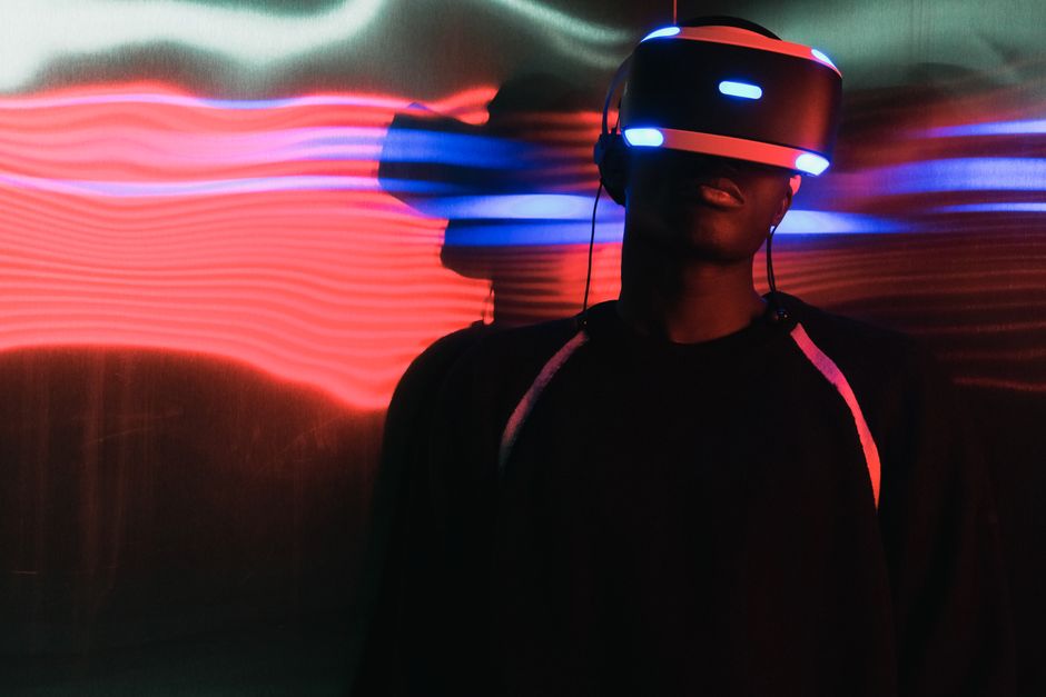 Osoba s VR naočalama okružena neonskim svjetlima, simbol digitalne inovacije